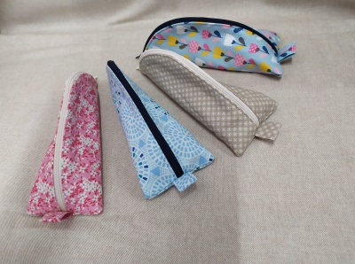 Quatro bolsas de tecido estreitas com padrões variados sobre superfície bege