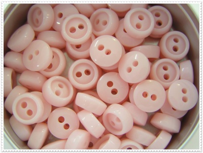 Botões redondos cor de rosa claro com dois orifícios