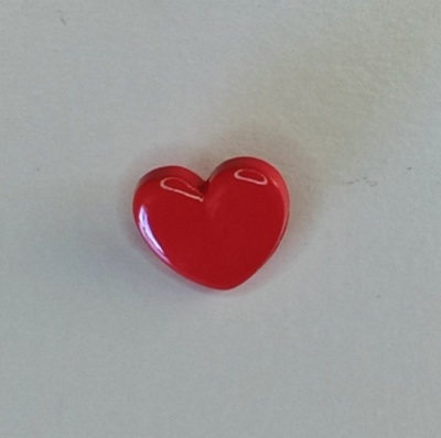 Botão vermelho em forma de coração sobre fundo branco