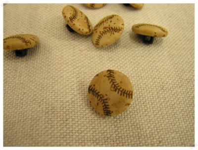 Botões redondos de madeira com padrão de bolas de baseball sobre tecido bege