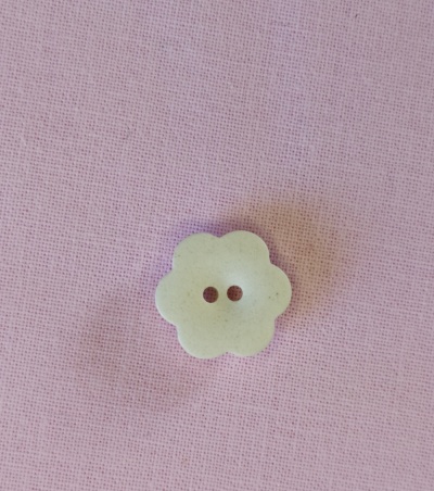 Botão flor bege claro sobre tecido rosa claro