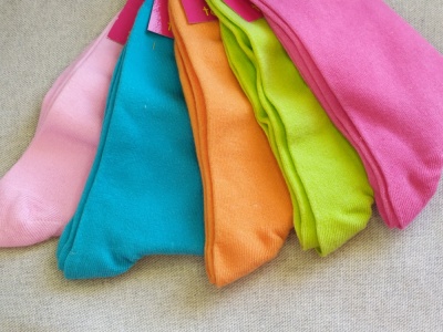 Meias coloridas em várias cores sobre superfície cinza