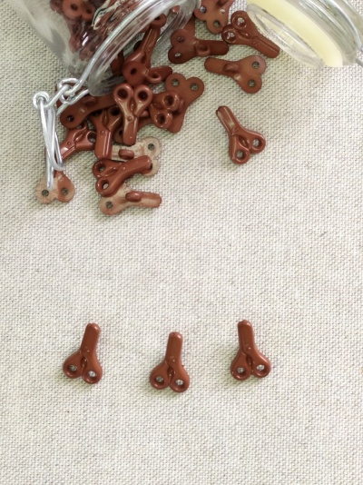 Potes de vidro e fechos metálicos marrons sobre tecido bege