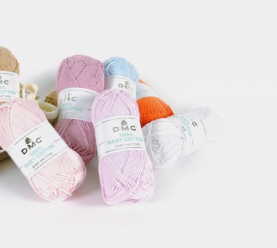 Novelos de lã DMC 100% Baby Cotton em várias cores sobre superfície branca