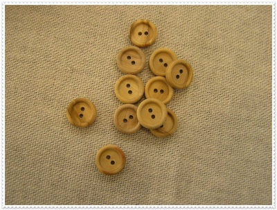 Botões de madeira clara em tecido bege texturizado