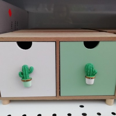Gaveteiro de madeira com gavetas branca e verde e puxadores de cacto