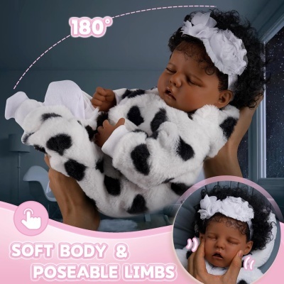 Boneca realista com corpo macio e membros posáveis vestindo fato de pelúcia branco com manchas pretas