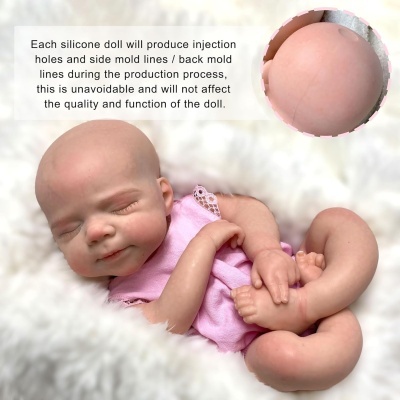 Boneca de silicone realista vestida de rosa sobre tecido branco macio