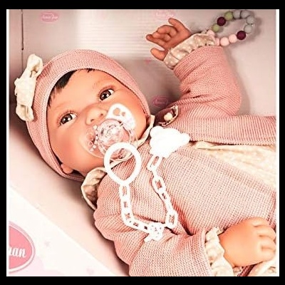 Boneca realista em fato de malha rosa e bege com chupeta e gorro