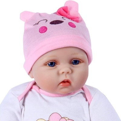 Boneca bebé com roupinha branca e gorro rosa com orelhas e laço