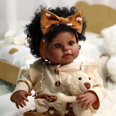 Boneca com cabelo encaracolado e roupa bege a segurar peluche