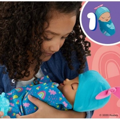 Criança a segurar boneca bebé com pijama e capuz azul com orelhas cor-de-rosa