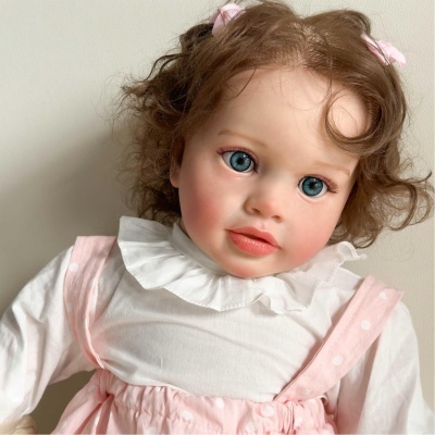 Boneca realista com vestido rosa com bolinhas e camisa branca