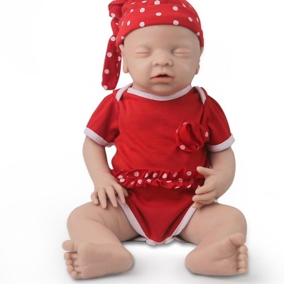 Boneca bebé dormindo com fato vermelho e gorro vermelho às bolinhas brancas