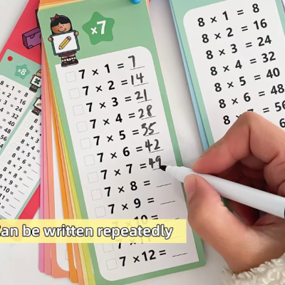 Cartões coloridos com tabuada e escrita repetida com marcador branco