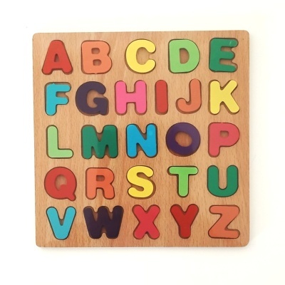 Puzzle alfabético em madeira com letras coloridas sobre tabuleiro de madeira clara