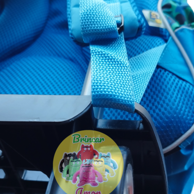Mochila azul com adesivo colorido e base preta com rodas