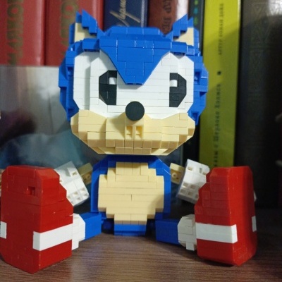 Figura de construção do Sonic sentada numa prateleira com livros