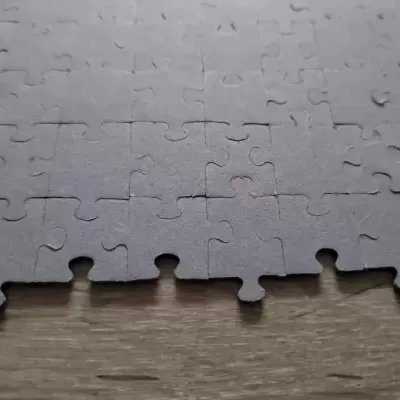 Puzzle cinzento fosco sobre superfície de madeira clara