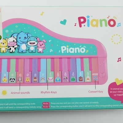 Caixa de piano de brinquedo cor-de-rosa com teclas coloridas e desenhos de animais