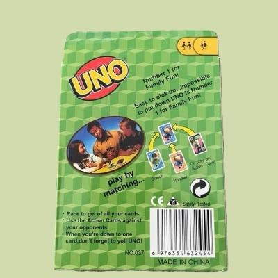 Embalagem verde do jogo de cartas UNO com texto e imagem de pessoas a jogar