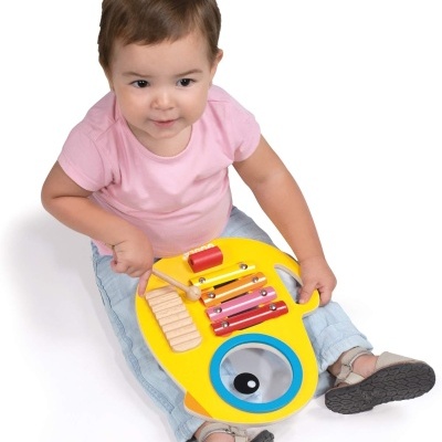 Criança com instrumento musical infantil colorido amarelo e metal