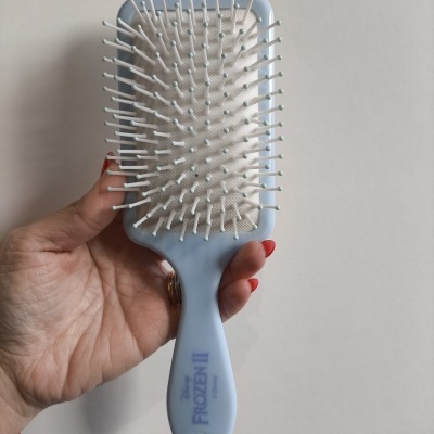 Escova de cabelo azul claro com cerdas brancas e texto 'Frozen'