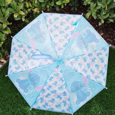 Guarda-chuva infantil azul com estampa Stitch sobre relva.