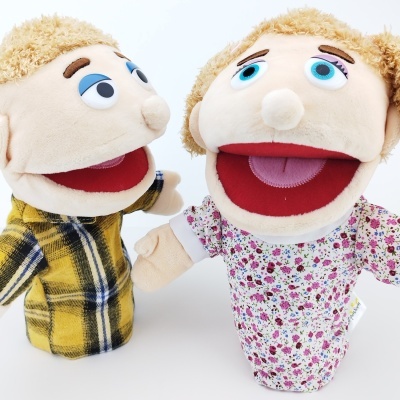 Duas marionetas de mão de peluche, uma com camisa xadrez amarela e outra com vestido floral