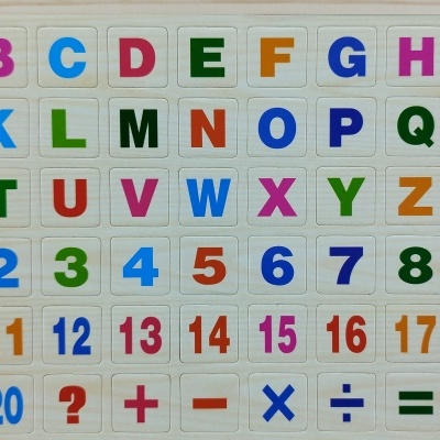 Tabuleiro de madeira com letras coloridas, números e símbolos matemáticos