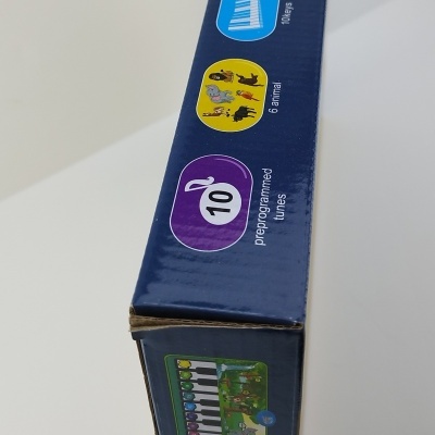 Caixa azul de brinquedo musical com animais e teclas coloridas