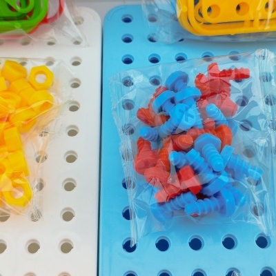 Peças de encaixe coloridas em tabuleiros perfurados branco e azul