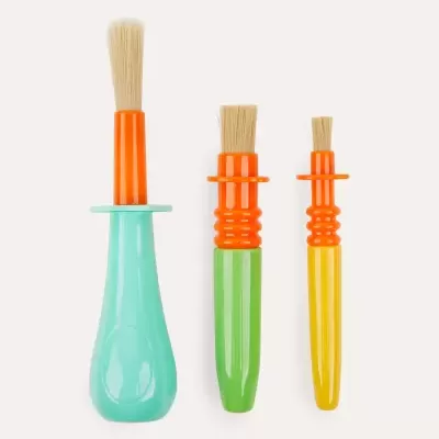 Três pincéis coloridos com cabos azuis, verdes e amarelos e cerdas claras