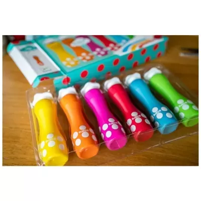 Seis marcadores coloridos com tampas brancas e pegadas brancas, em bandeja transparente sobre mesa de madeira.