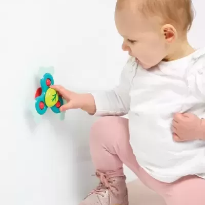 Bebé a tocar toy de parede colorido com padrão de relâmpago.