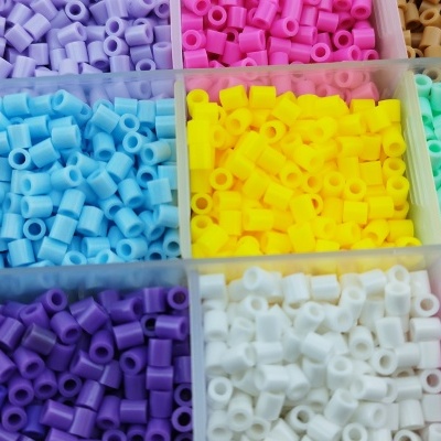 Recipientes transparentes com miçangas cilíndricas coloridas organizadas por cor