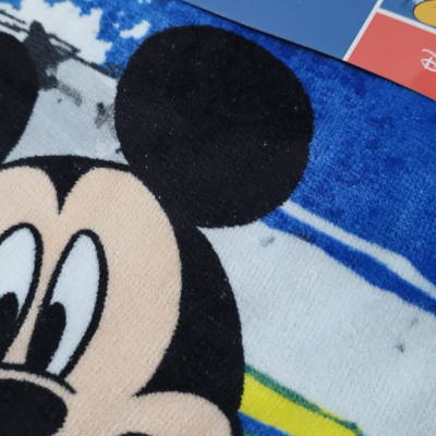 Poncho azul com estampa do Mickey Mouse e embalagem com marca Disney.