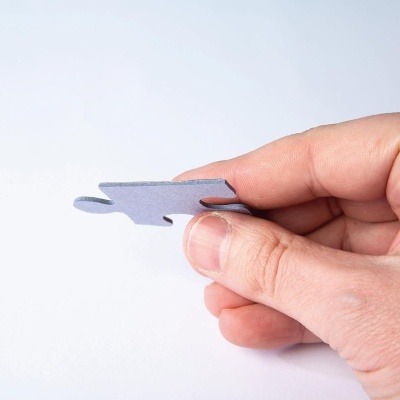 Mão segurando peça de puzzle azul claro