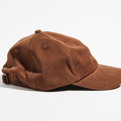 Boné castanho de tecido vistoso sobre fundo branco