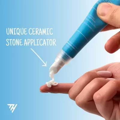 Tubo azul de creme com aplicador cerâmico a dispensar creme para um dedo