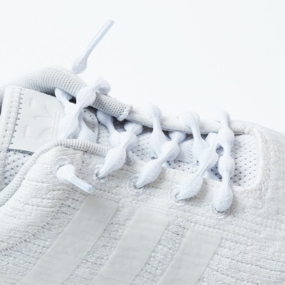 Ténis desportivo branco com cadarços e três riscas laterais