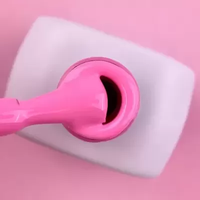 Pincel de unha eletrónico rosa sobre superfície branca quadrada