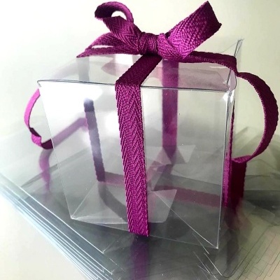 Caixa transparente com fita roxa e fundo branco