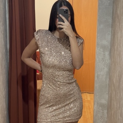 Vestido dourado com lantejoulas e ombros almofadados