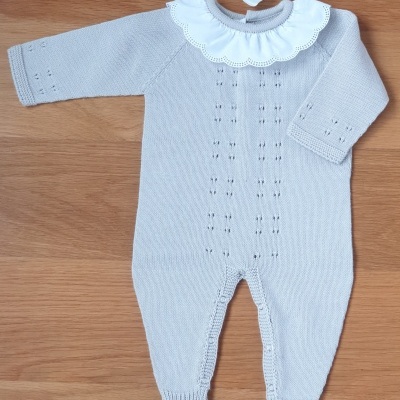 Fato de bebé cinza claro com gola branca bordada e pés fechados sobre madeira