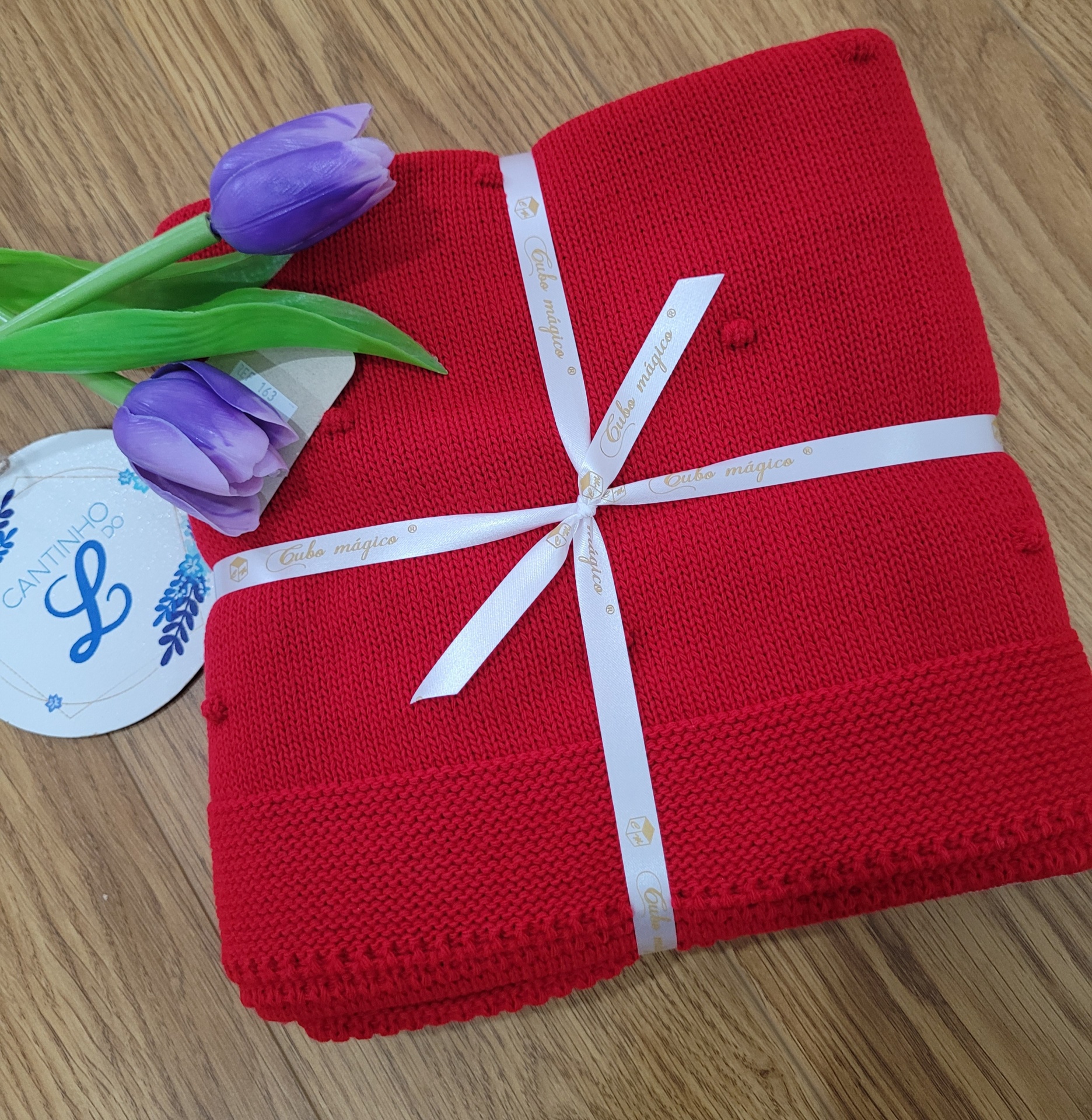 Manta bolinhas VERMELHO Cobertor vermelho tricotado com fita branca, flores roxas e etiqueta circular