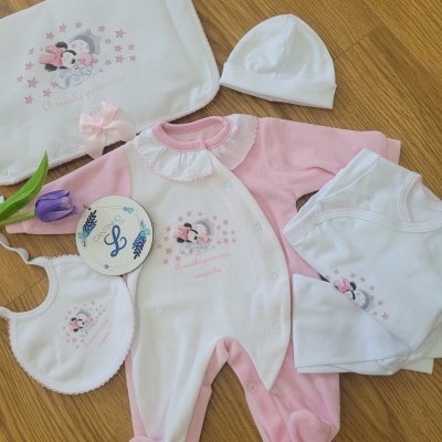 Conjunto de roupa de bebé rosa e branco com estrelas e personagens infantis
