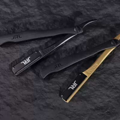 Três navalhas de barbear JRL em várias cores sobre superfície preta.