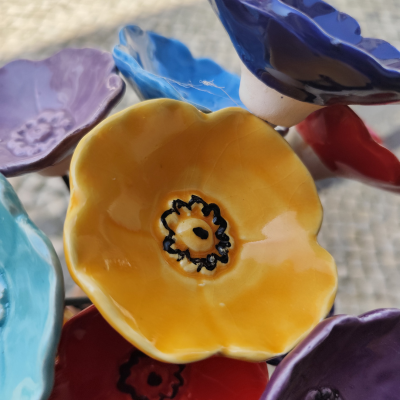 Flores em cerâmica esmaltada coloridas com detalhes pretos no centro