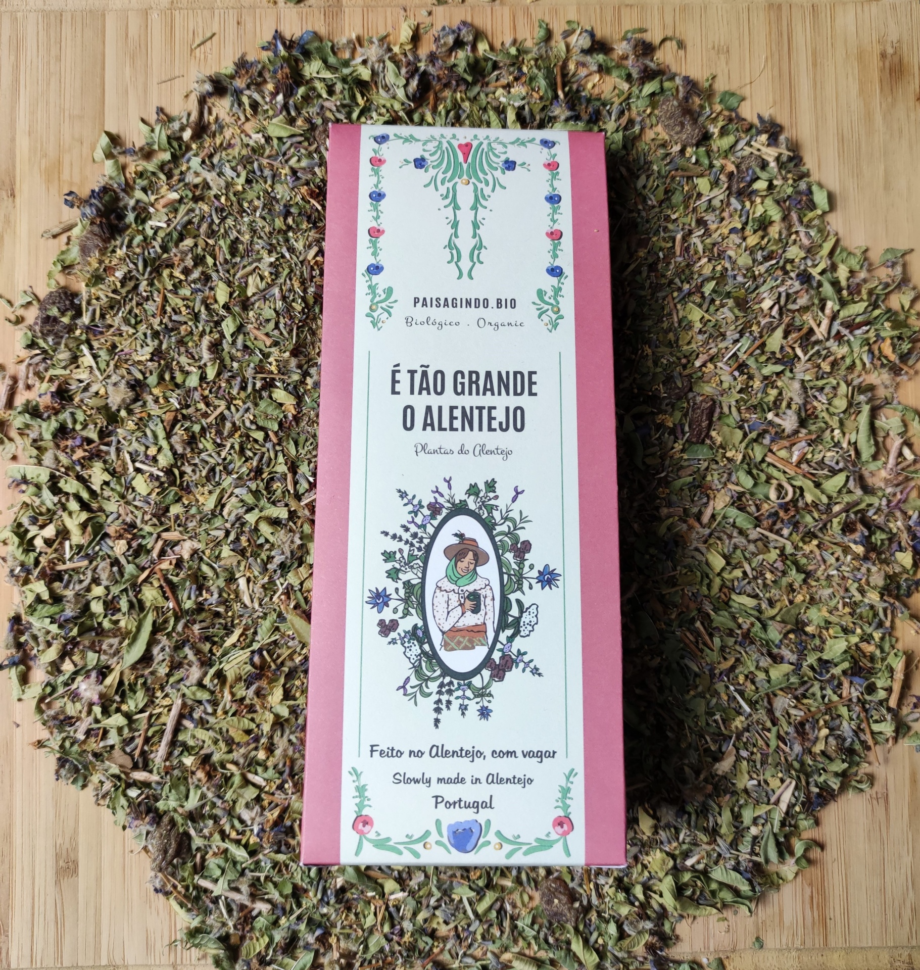 Pacote de chá É TÃO GRANDE O ALENTEJO com folhas secas ao redor sobre madeira